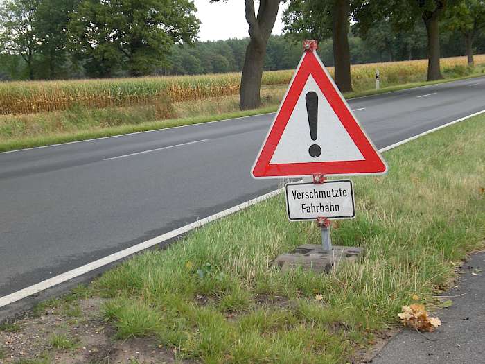 Verkehrsschild verschmutzte Fahrbahn